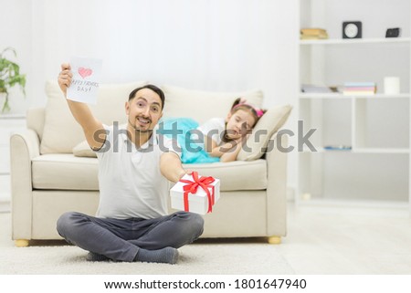 Photo of handsome young man at home with his little cute girl.