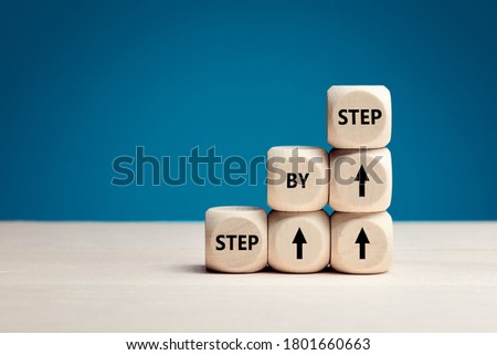 The word step by step on wooden cubes. Achievement or progress in business career. Royalty-Free Stock Photo #1801660663