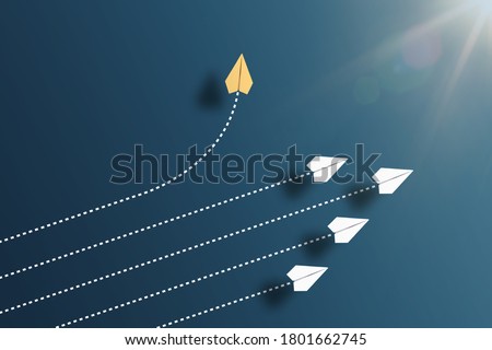 paper planes flying in formation in one direction on blue background and one paper glider going in different direction, breaking new ground and stepping out of the line concept Royalty-Free Stock Photo #1801662745
