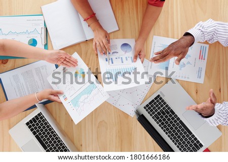 Hands of finance department managers analyzing reports on big table, view from the top Royalty-Free Stock Photo #1801666186
