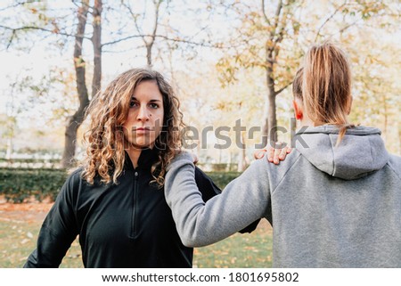 A couple of women training together outdoors in the park