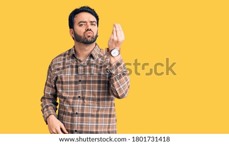 Young hispanic man wearing casual clothes doing italian gesture with hand and fingers confident expression 