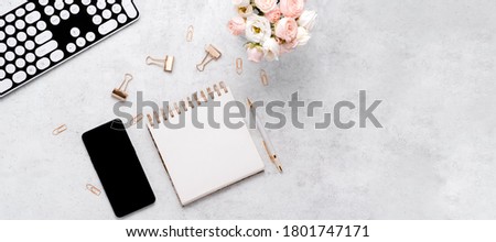 Stationery business flatlay creative composition. Top horizontal view of envelope, spiral blocj paper clips and a pen on abstract pink background