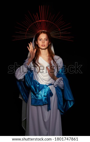 The Virgin Mary portrait on a dark background with rays of light. Modern art in religion. 