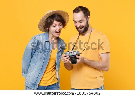 Excited tourists couple friends man woman in summer clothes hat isolated on yellow background. Passenger traveling abroad on weekends. Air flight journey. Taking pictures on retro vintage photo camera