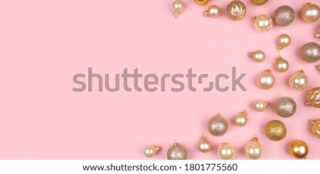 Festive pink background with gold and silver christmas balls. Flat lay, top view. Copy space for your text.