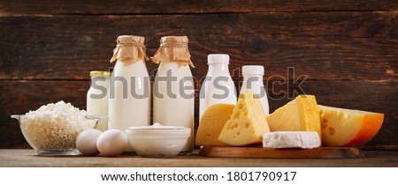 Various types of dairy products : milk, cheese, cottage cheese, eggs, yogurt on a wooden background Royalty-Free Stock Photo #1801790917