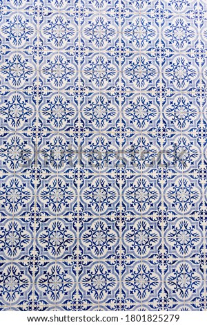 Vertical photo of traditional vintage tiles with blue geometric borders in Aveiro in Portugal