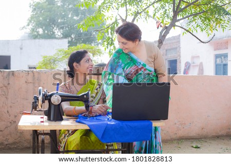 Senior woman and adult daughter working on sewing machine with laptop Royalty-Free Stock Photo #1801828813