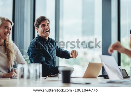 Cheerful businesspeople sitting in conference room. Businessman and woman smiling during a meeting in office. Royalty-Free Stock Photo #1801844776