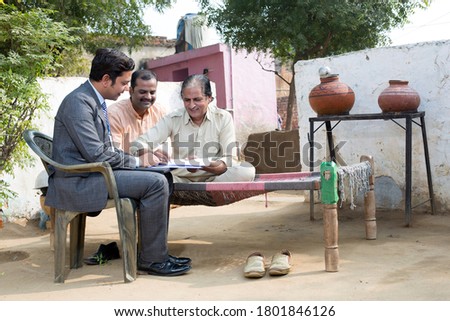 Life insurance agent with client at village