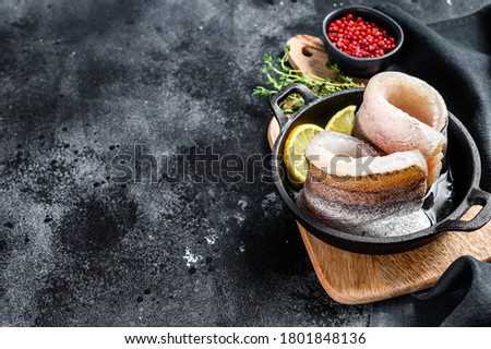 Recipe for cooking fillet of hake fish in a pan. Black background. Top view. Copy space