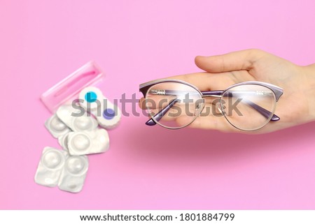 Glasses and contact lenses on a pink background. Vision correction. Glasses for sight. Glasses or contact lenses.