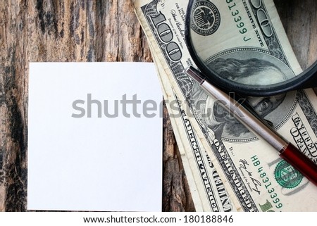 Magnifying glass on american dollars money , stick note and pen