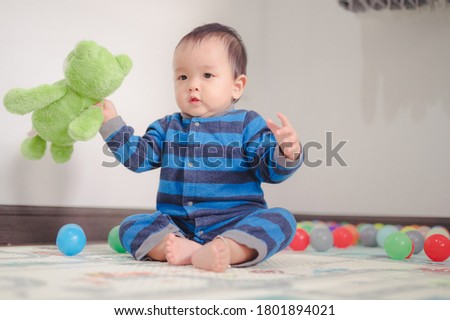 Kid playing with ball on soft carpet in children room