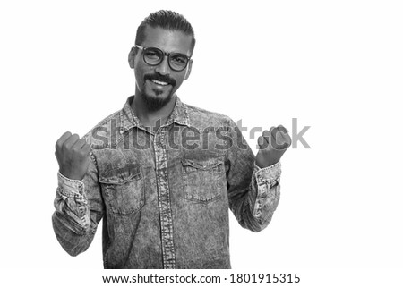 Portrait of happy young handsome bearded Indian hipster man