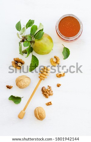 Honey, apples and walnuts on white wooden background. Overhead food shots. Copy space composition