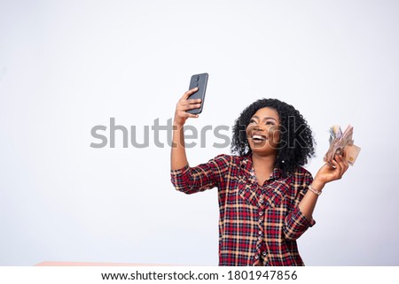 pretty black lady taking a selfie with a wad of cash