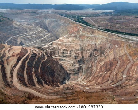 Open pit ore mining.
Photo of a pit for mining ore from the air. A string of roads in the mountains dug by man.