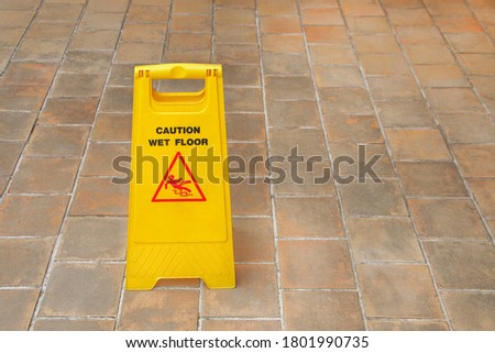 one yellow plastic wet floor sign on tile floor.