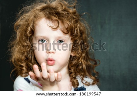 Curly girl blowing mouth with hand.