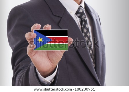 Businessman in suit holding a business card with South Sudan Flag 