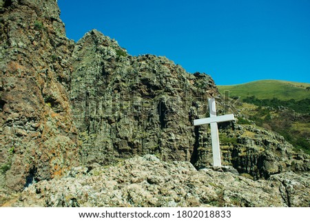 White cross in mountains on hill