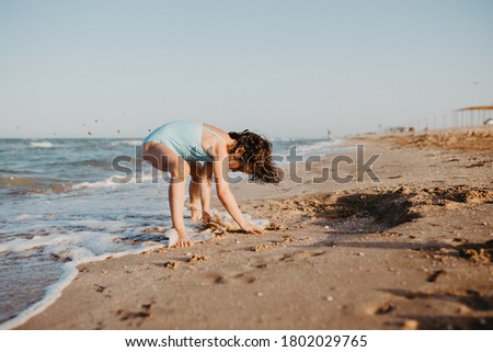 happy child girl playing on beach in the day time. Lifestyle photography