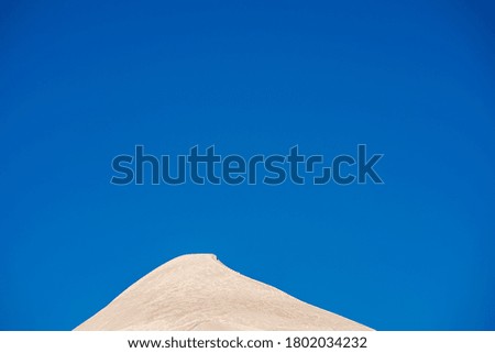 Summit of an alpine peak against the blue sky. Wallpaper photo. Sharp snow covered peak and blue sky with space for copy.