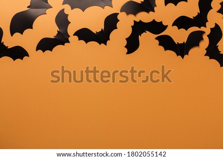 Halloween black paper bats on orange background. Top view Copy space - Image