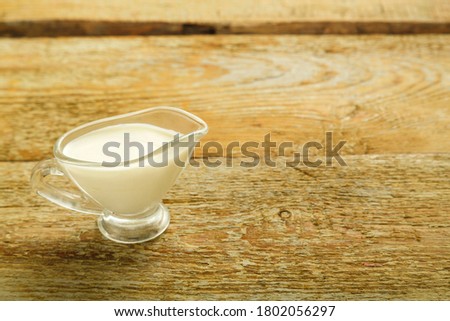 cream in a jug on a wooden table.