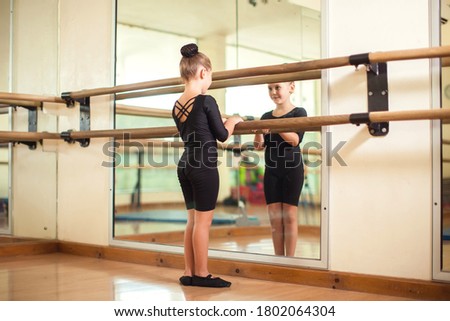 Kid girl at gymnastic class doing exercises. Children and sport concept