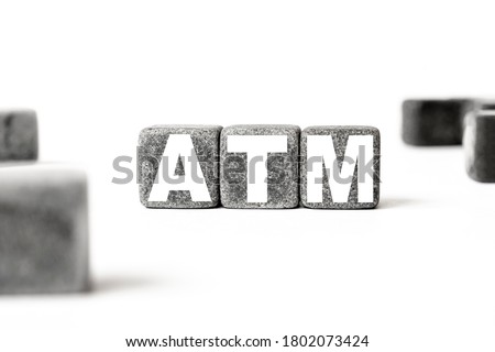 three stone cubes inscribed with the word ATM Asynchronous Transfer Mode among the cubes on a white background. Strong business concept
