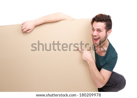 Portrait of a confident young man smiling and pointing finger to empty space on poster