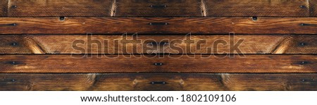 Old wooden background. Wooden wall. Dark vintage background of wooden planks. Rustic background. Wide grunge banner with wood texture.
