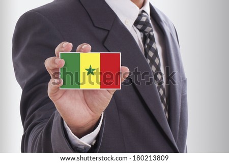 Businessman in suit holding a business card with Senegal Flag 