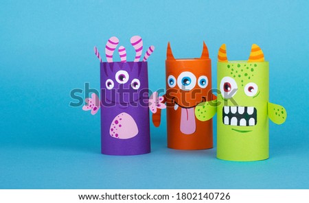 colorful monsters made out of toilet paper on a blue background. handmade work. the concept of reuse