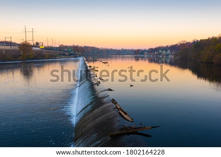 Philadelphia, Pennsylvania, USA dam on the Schuylkill River with Boathouse Row in the distance at dawn.