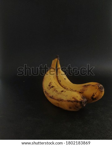 Yellow banana taken from eye level angle. Minimalist photography, dark mood style.