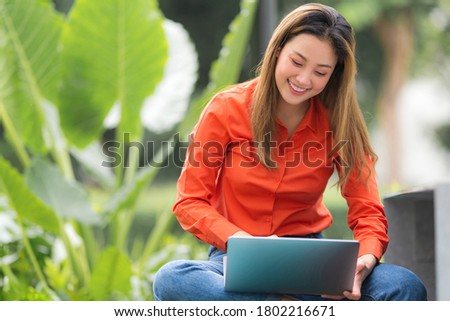 Beautiful young woman using laptop sitting at coffee shop park 