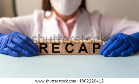 the concept of the word summarize on cubes on a medical background, doctor holding word recap