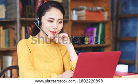 Working asian woman in the living room. Telemeeting. Video conference. Remote work. Royalty-Free Stock Photo #1802220898