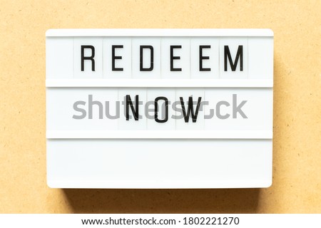 Lightbox with word redeem now on wood background