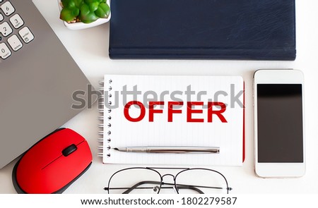 OFFER text with fountain pen, decorative plant, keyboard and notepad on wooden background. Business concept