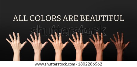 Hands of different people and text ALL COLORS ARE BEAUTIFUL on dark background. Stop racism Royalty-Free Stock Photo #1802286562
