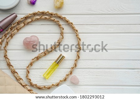 Women's flatlay with handbag, cosmetics, perfume and minerals on white wooden background. Concept of beauty, self love, self-care and inner peace.