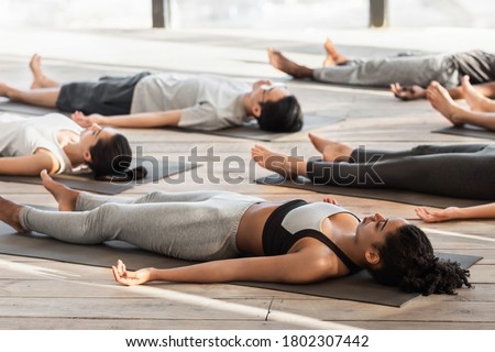 Savasana Pose. Diverse Yoga Class Members Meditating On Floor, Lying On Mats In Studio During Group Training, Free Space Royalty-Free Stock Photo #1802307442