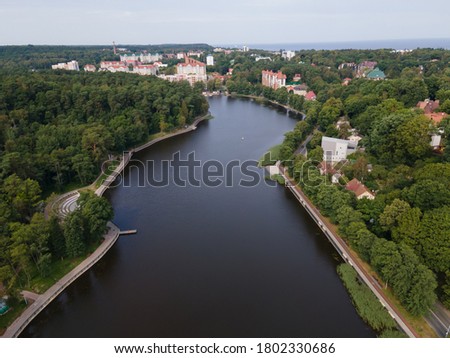 Drone view of quite lake in Svelogorsk in sunny day, forest around water
