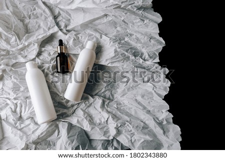 bottles of cosmetics on white crumpled paper