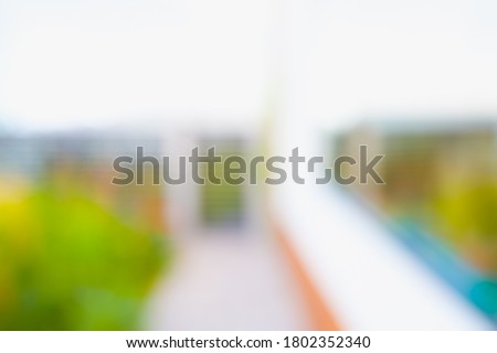 BLURRED OFFICE BACKGROUND WITH WINDOW REFLECTIONS AND GREEN FLOWERS